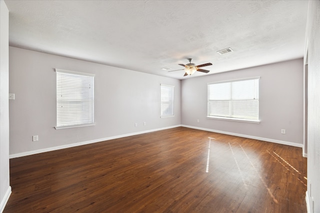 spare room with ceiling fan, dark wood-type flooring, and a textured ceiling