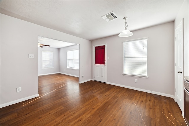 interior space with ceiling fan, dark hardwood / wood-style flooring, and a textured ceiling