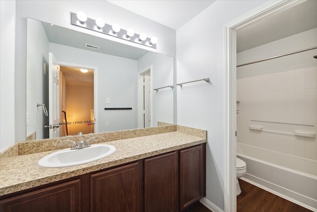 full bathroom with hardwood / wood-style floors, vanity, toilet, and shower / tub combination