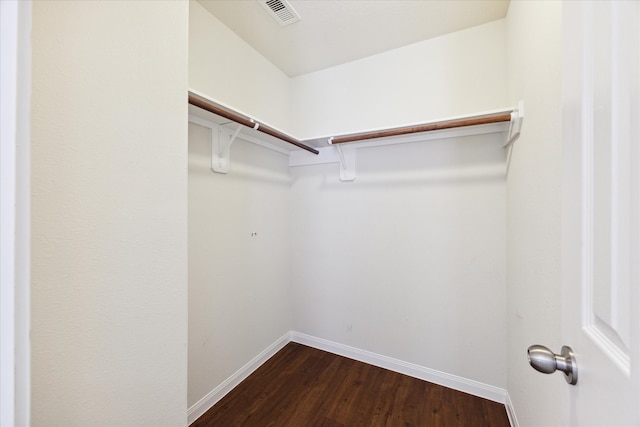 spacious closet with dark hardwood / wood-style flooring