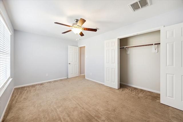 unfurnished bedroom featuring ceiling fan, light carpet, and a closet