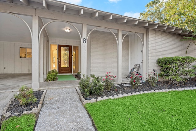 view of exterior entry with a lawn