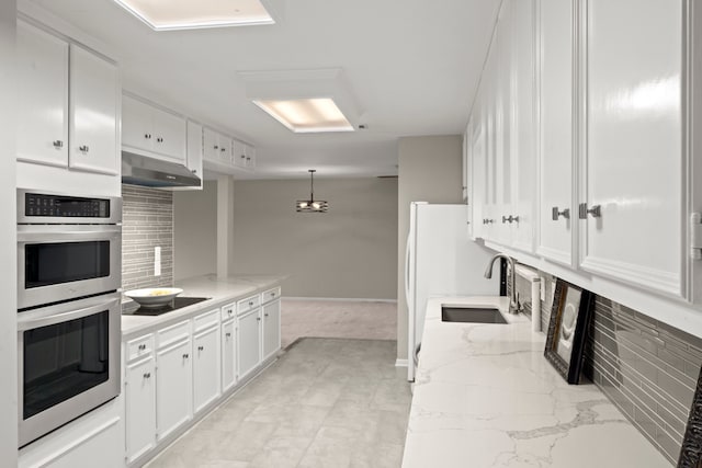 kitchen with white cabinetry, backsplash, and range hood