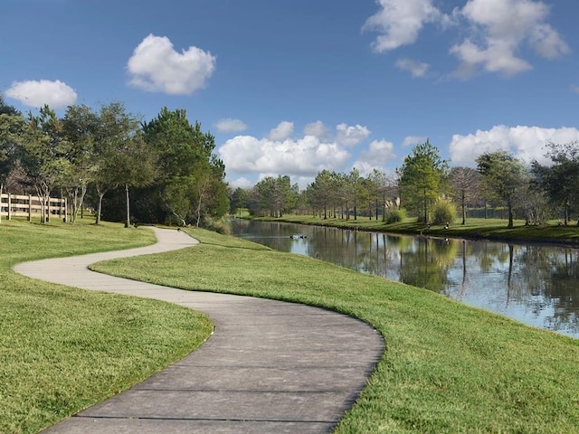 view of property's community with a yard and a water view