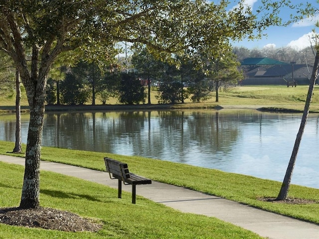 view of home's community with a lawn and a water view