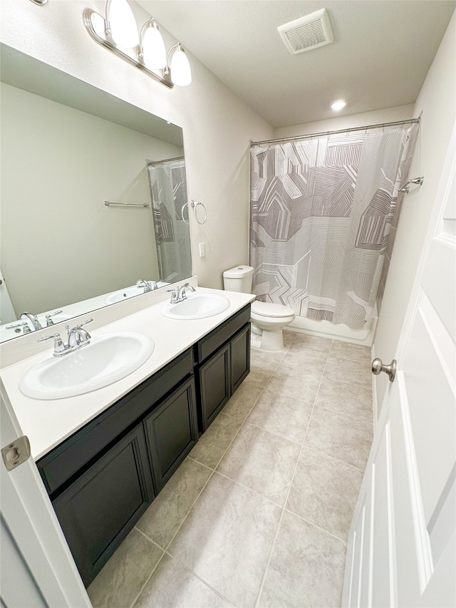 bathroom with tile patterned flooring, vanity, and toilet