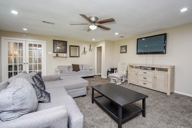 carpeted living room with ceiling fan, french doors, and a textured ceiling