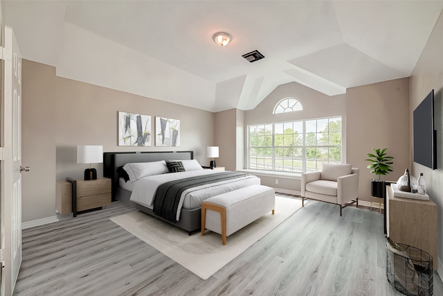 bedroom featuring light hardwood / wood-style floors and vaulted ceiling