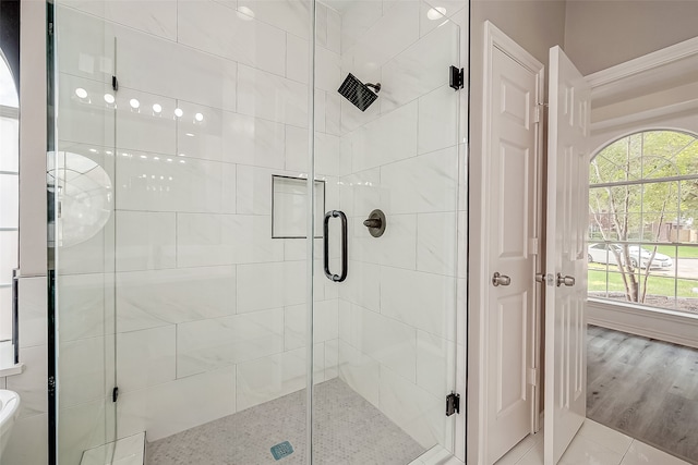 bathroom featuring wood-type flooring and an enclosed shower