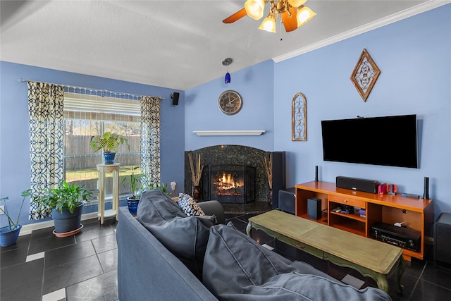 living room with ceiling fan, a high end fireplace, crown molding, a textured ceiling, and dark tile patterned flooring