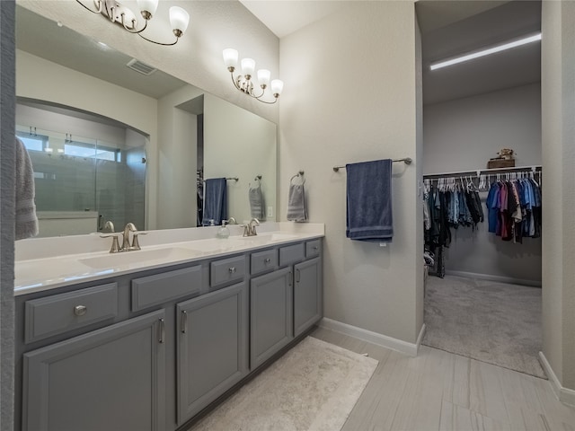 bathroom featuring a shower with door and vanity