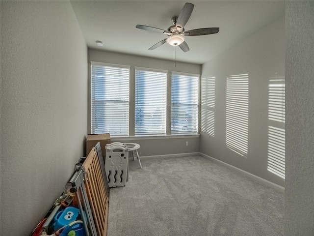 spare room with ceiling fan and light colored carpet