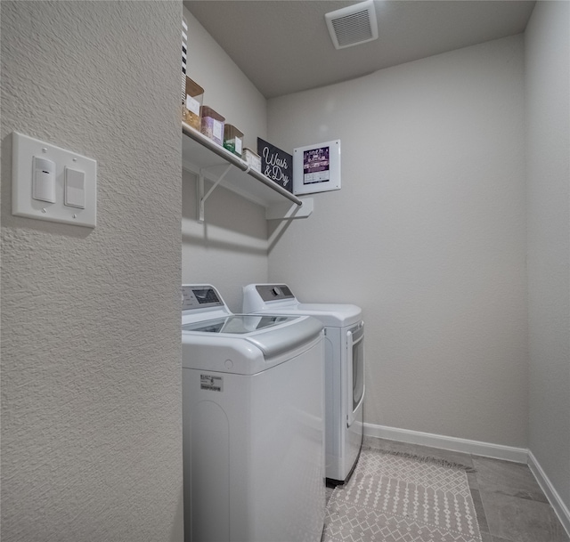 laundry area with independent washer and dryer and light tile patterned flooring