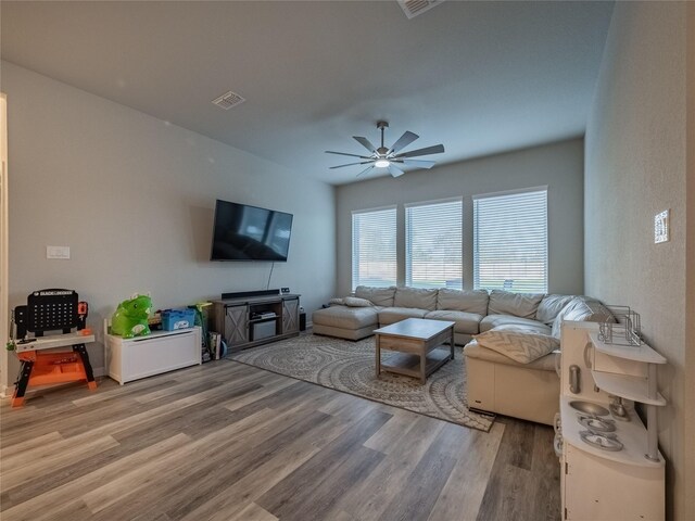 living room with ceiling fan and light wood-type flooring