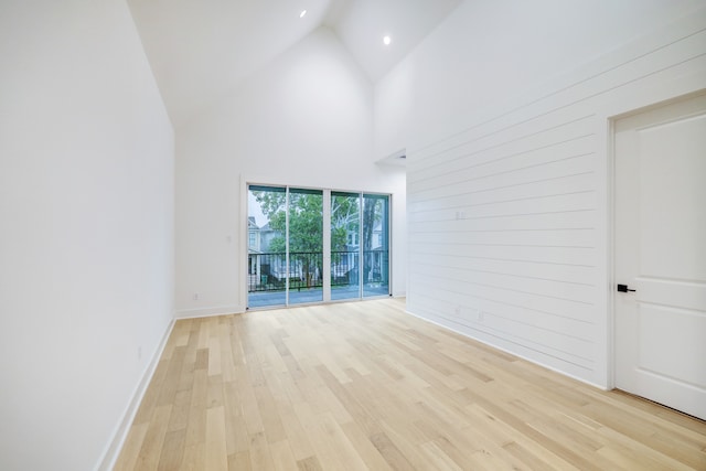 unfurnished room with high vaulted ceiling and light hardwood / wood-style floors