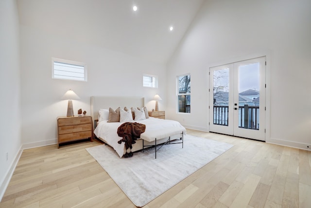 bedroom featuring multiple windows, access to exterior, high vaulted ceiling, and french doors