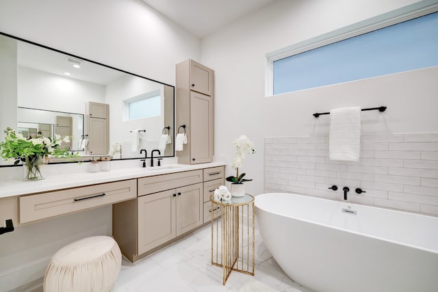 bathroom with a washtub, vanity, and a wealth of natural light