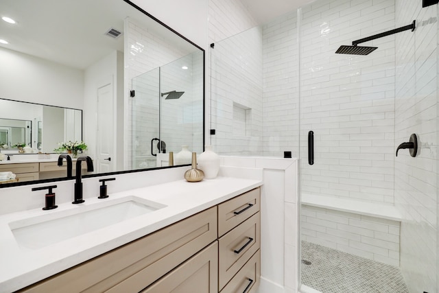 bathroom with vanity and a shower with shower door