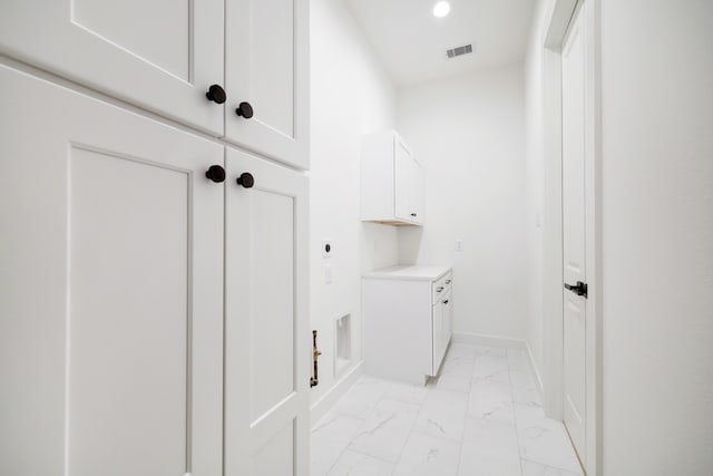 clothes washing area featuring cabinets and electric dryer hookup