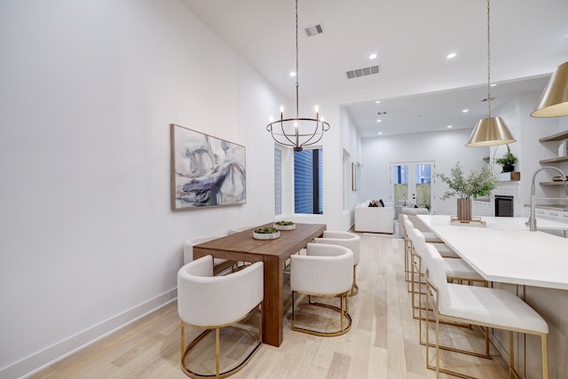 dining space with french doors, sink, and light hardwood / wood-style flooring