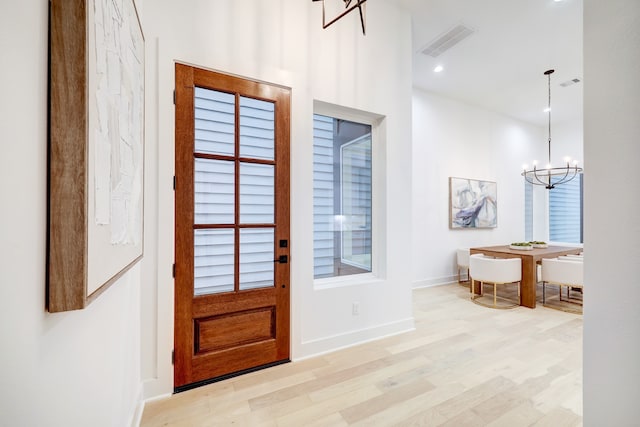 entryway with a notable chandelier and light hardwood / wood-style floors