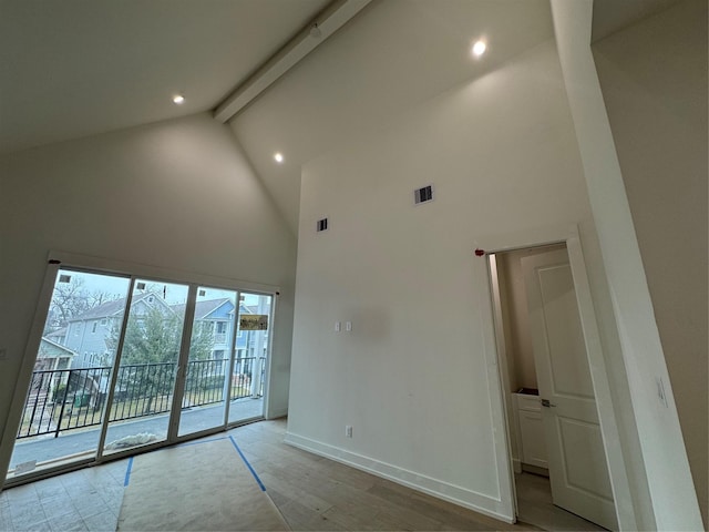 spare room featuring beam ceiling, high vaulted ceiling, and light hardwood / wood-style floors