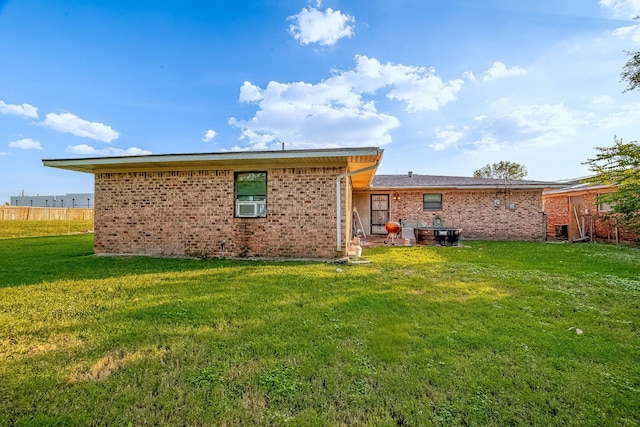 rear view of property with cooling unit and a lawn