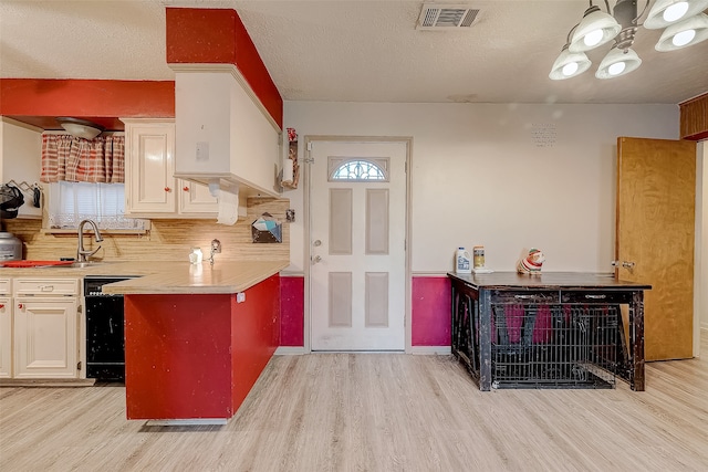 kitchen with dishwasher, sink, a textured ceiling, decorative backsplash, and light wood-type flooring