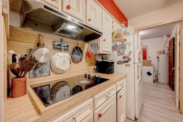 kitchen with wooden counters, a textured ceiling, water heater, light hardwood / wood-style floors, and washer / dryer