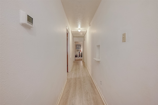 hallway featuring a textured ceiling and light hardwood / wood-style flooring