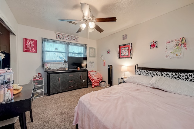 carpeted bedroom with ceiling fan and a textured ceiling