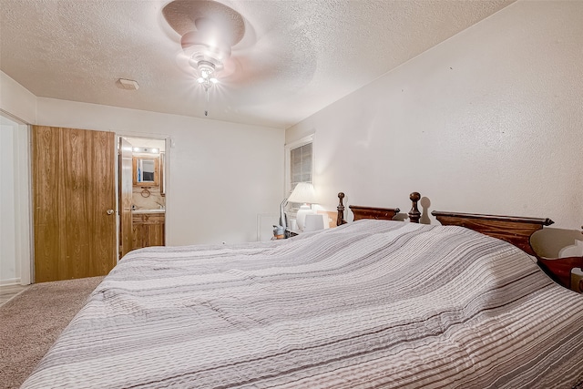 carpeted bedroom featuring ceiling fan, a textured ceiling, and connected bathroom