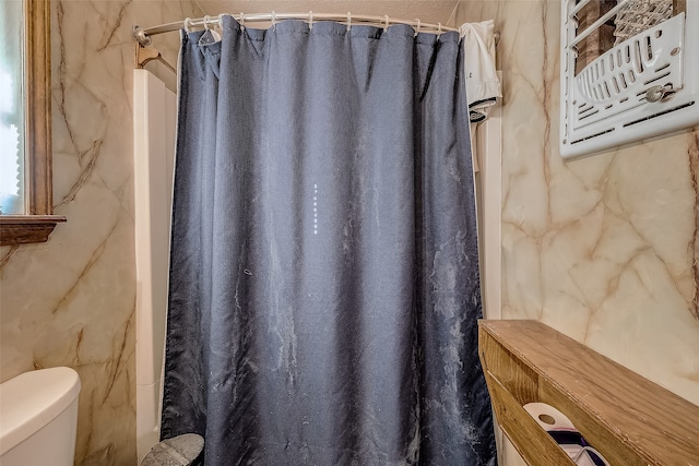 bathroom featuring walk in shower and toilet