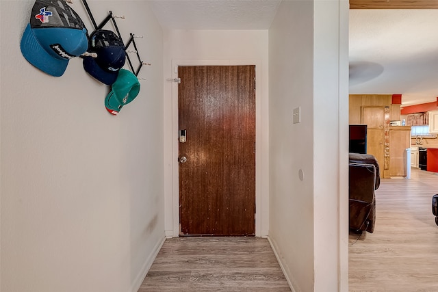 hallway with light hardwood / wood-style floors