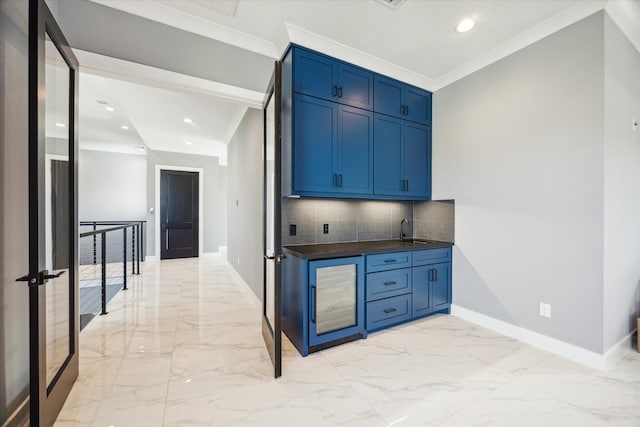 kitchen featuring backsplash, sink, ornamental molding, and blue cabinets