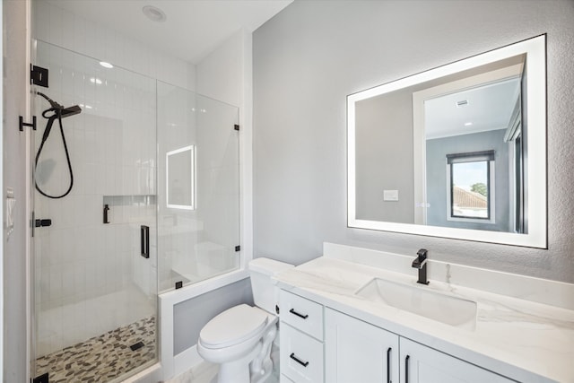 bathroom featuring vanity, toilet, and a shower with shower door