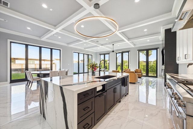 kitchen with a large island, plenty of natural light, sink, and coffered ceiling