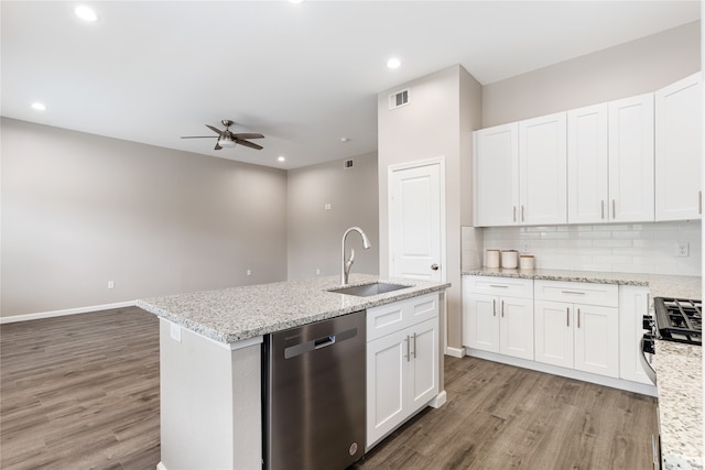 kitchen with hardwood / wood-style floors, white cabinets, sink, light stone countertops, and appliances with stainless steel finishes