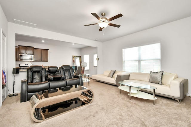 carpeted living room with ceiling fan