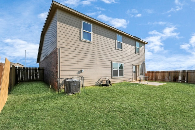 back of house with a lawn, central air condition unit, and a patio