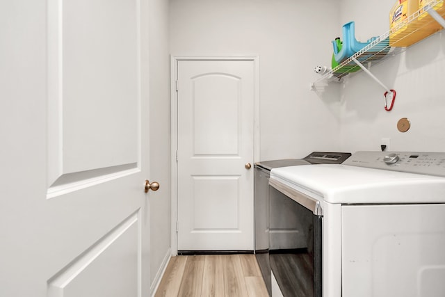 washroom with washer and dryer and light hardwood / wood-style flooring