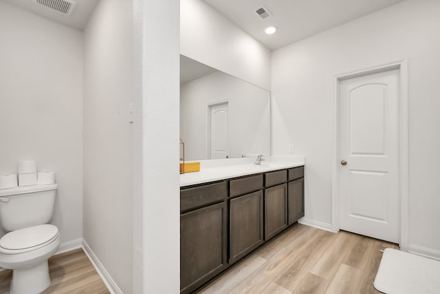 bathroom featuring toilet, vanity, and hardwood / wood-style flooring