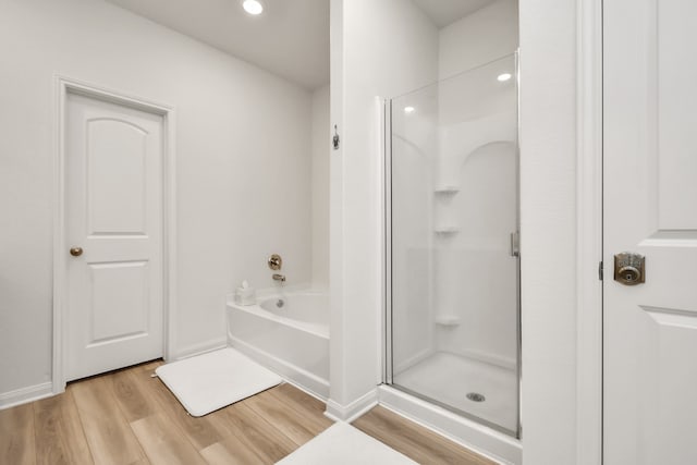 bathroom with plus walk in shower and hardwood / wood-style flooring