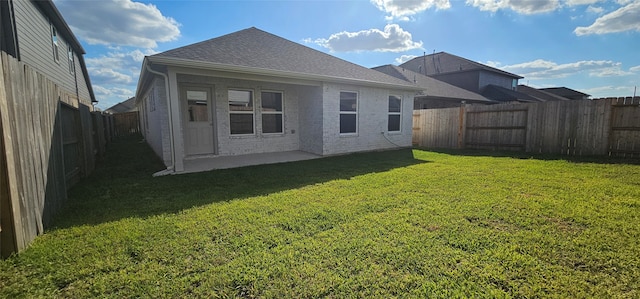 rear view of property with a yard and a patio