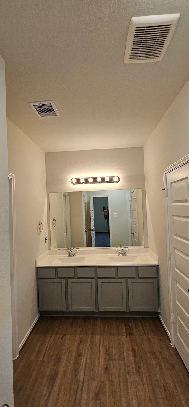 bathroom with a textured ceiling, vanity, and hardwood / wood-style flooring