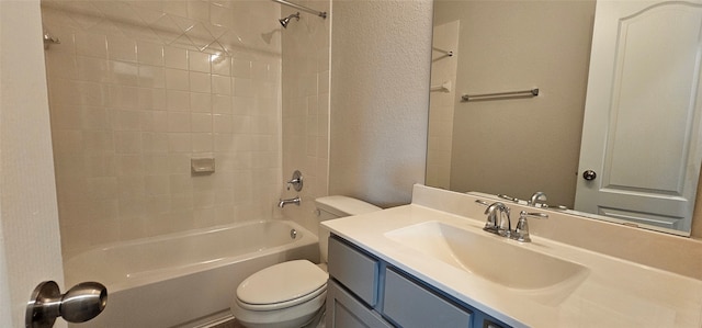 full bathroom featuring vanity, tiled shower / bath combo, and toilet