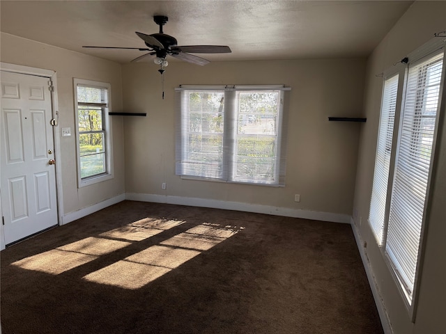 carpeted foyer with a wealth of natural light and ceiling fan