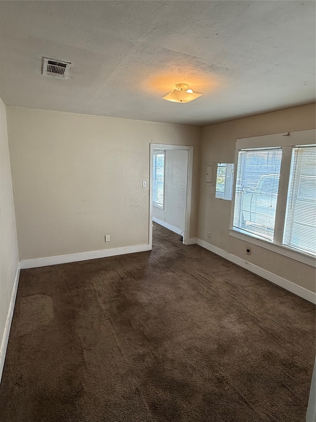 carpeted empty room featuring a textured ceiling