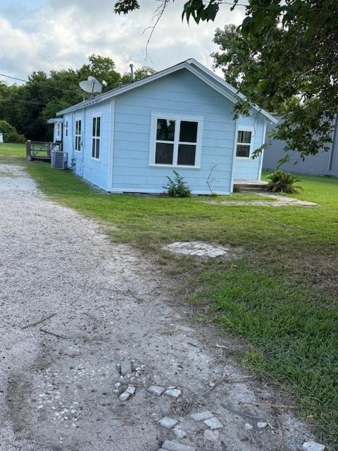 4822 W Cedar Bayou Lynchburg Rd, Baytown, TX 77521 - view of front facade featuring a front yard and central AC unit