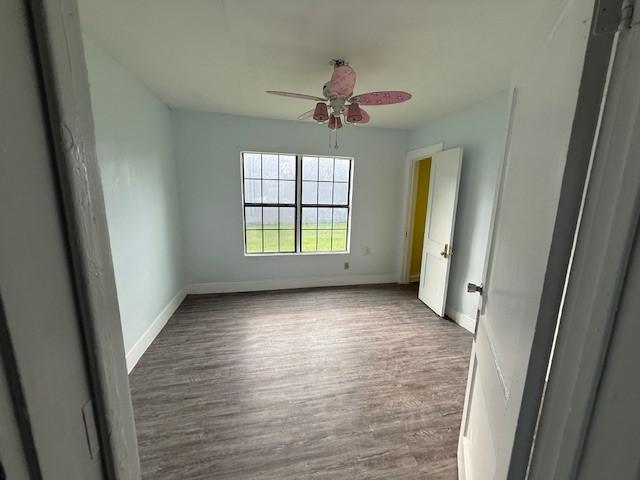 4822 W Cedar Bayou Lynchburg Rd, Baytown, TX 77521 - spare room featuring wood finished floors, ceiling fan, and baseboards